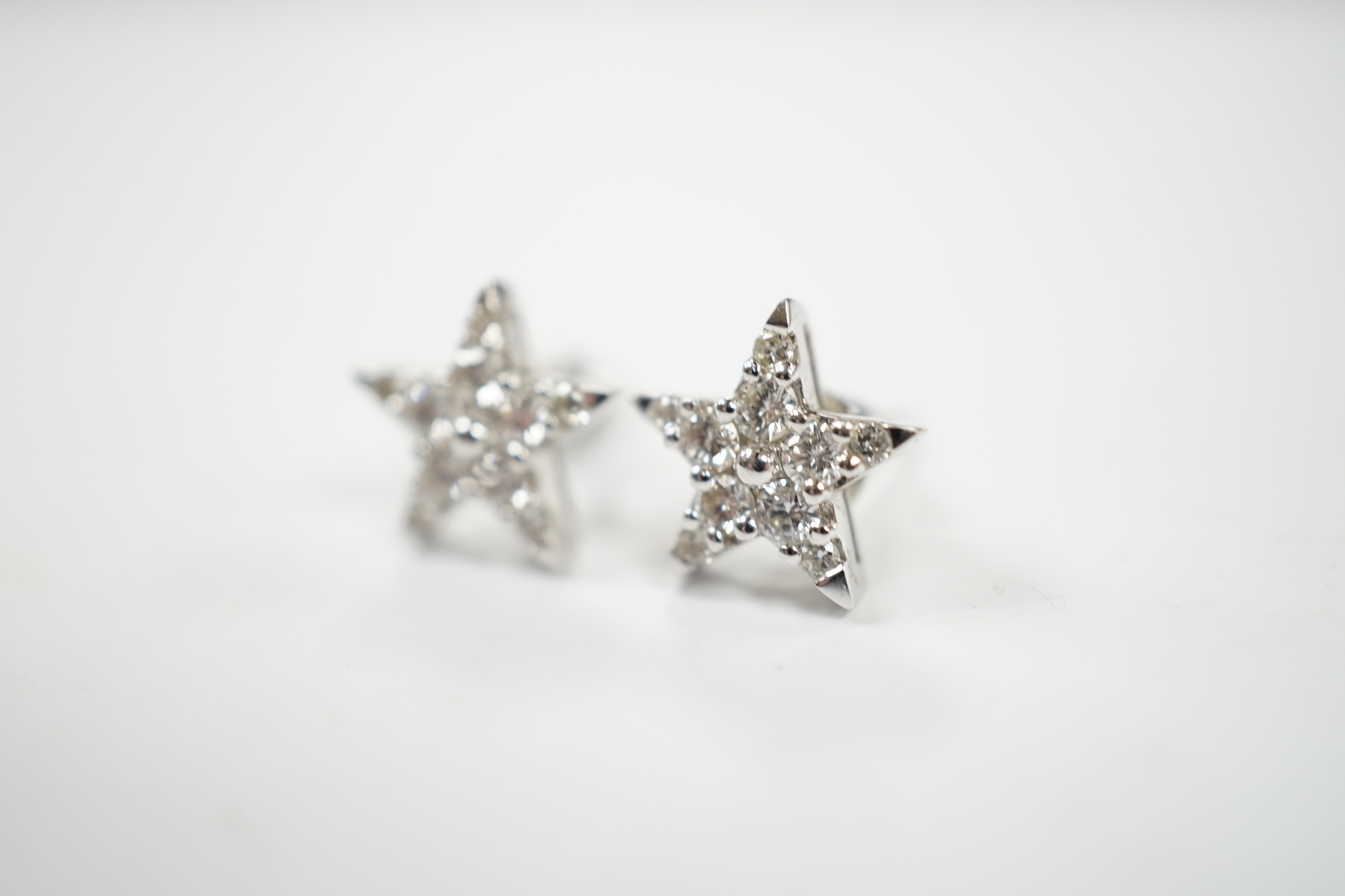 A modern pair of 18ct white gold and diamond chip star shaped ear studs, 10mm, gross weight 2.2 grams.